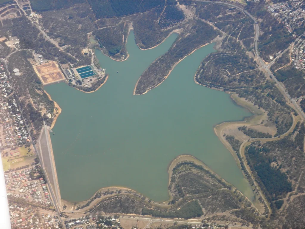 Aerial view of Happy Valley Reservoir, with the dam wall on the left and surrounding suburbs