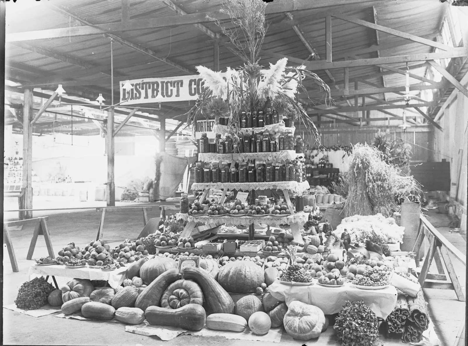 Black-and-white photo from about 1914 of a tiered display of pumpkins, fruit and preserves at the Uraidla and Summertown Show